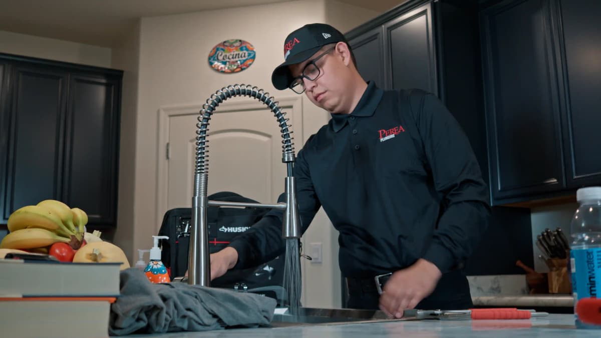 Adan Perea performing drain cleaning
